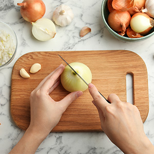 Slicing a yellow onion on a cutting board